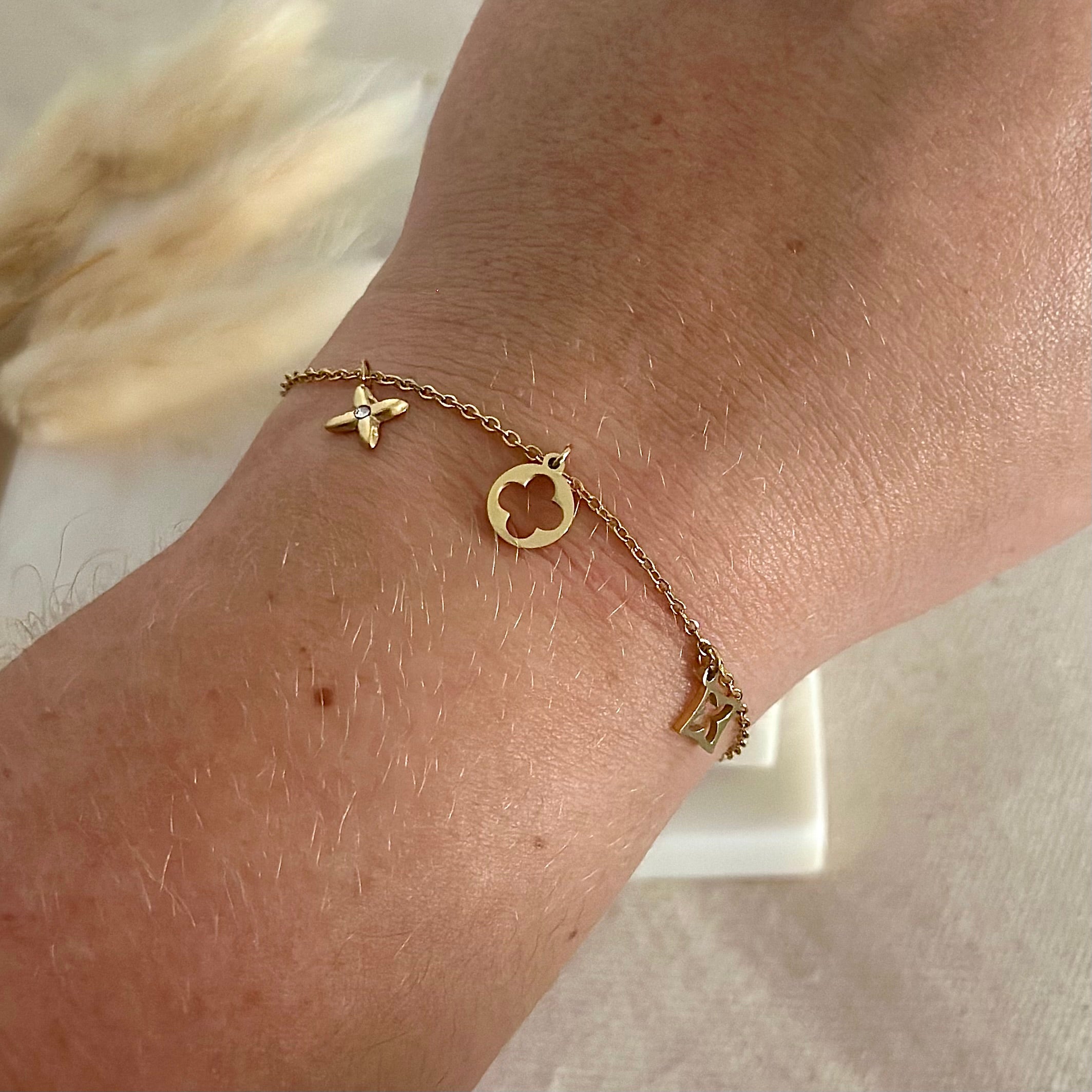 Bracelet doré porté en acier inoxydable pour femme fin avec charms breloques trèfles et strass prise face - Zoela