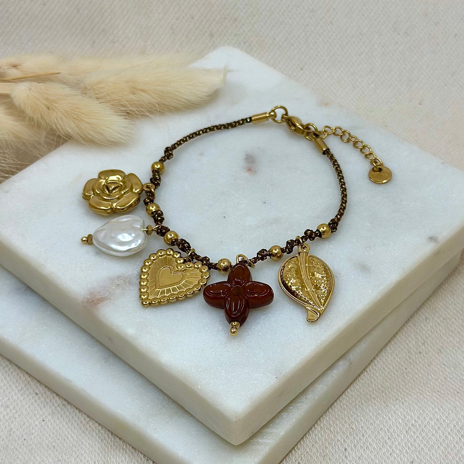 Bracelet doré en acier inoxydable pour femme tissu tressé marrons avec charms breloques fleur, coeur, feuille et trèfle prise face - Zoela